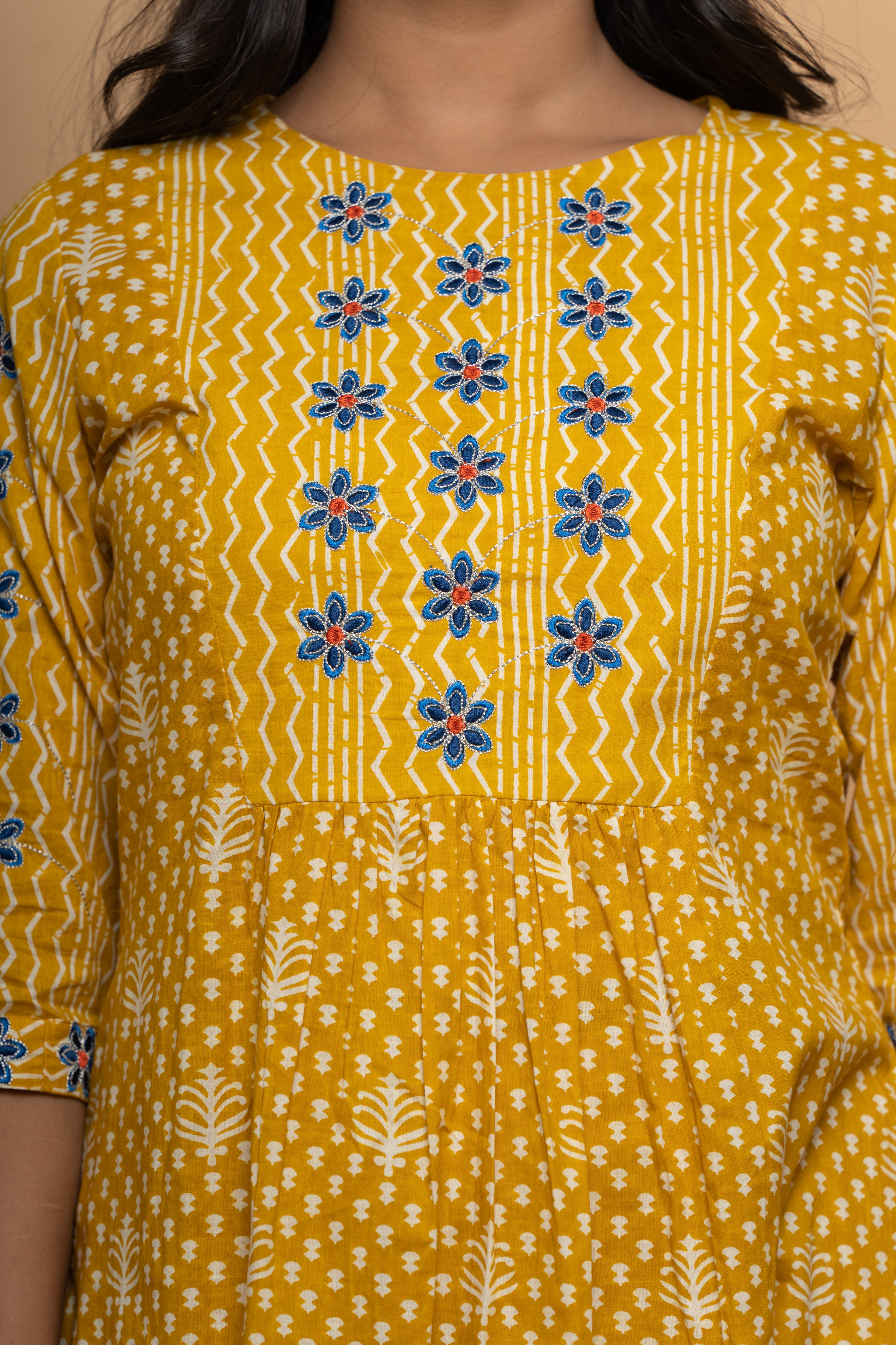 Close-up embroidery and fabric detail on mustard cotton suit set by Poshida