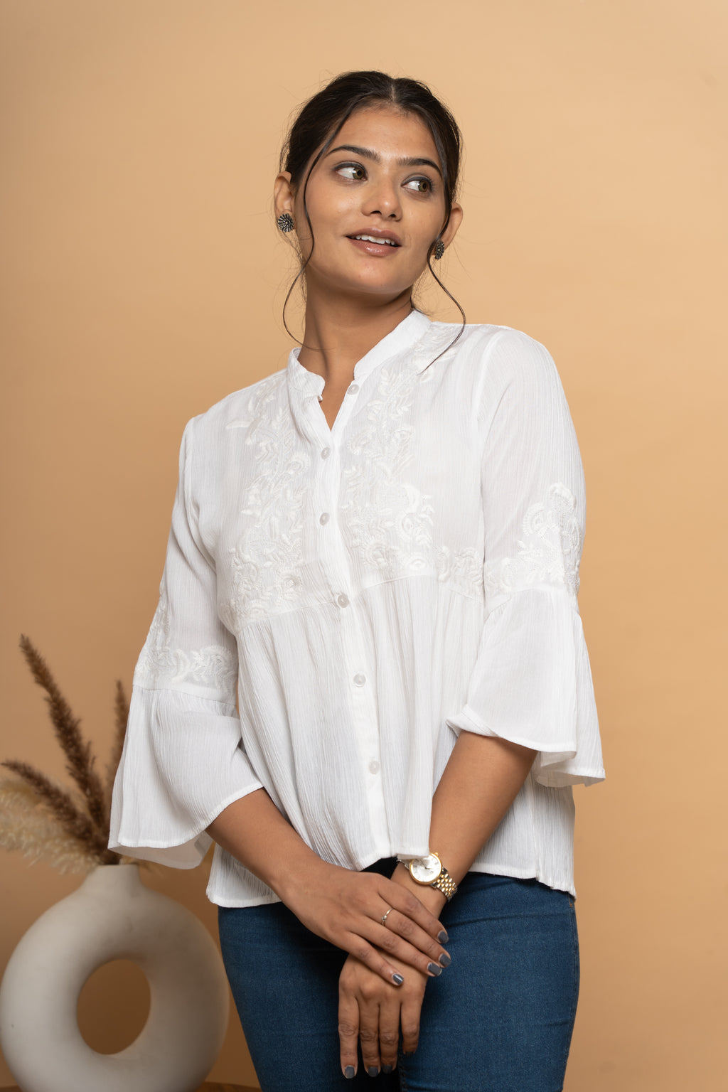 Close-up schiffli embroidery detail on white flared top by Poshida