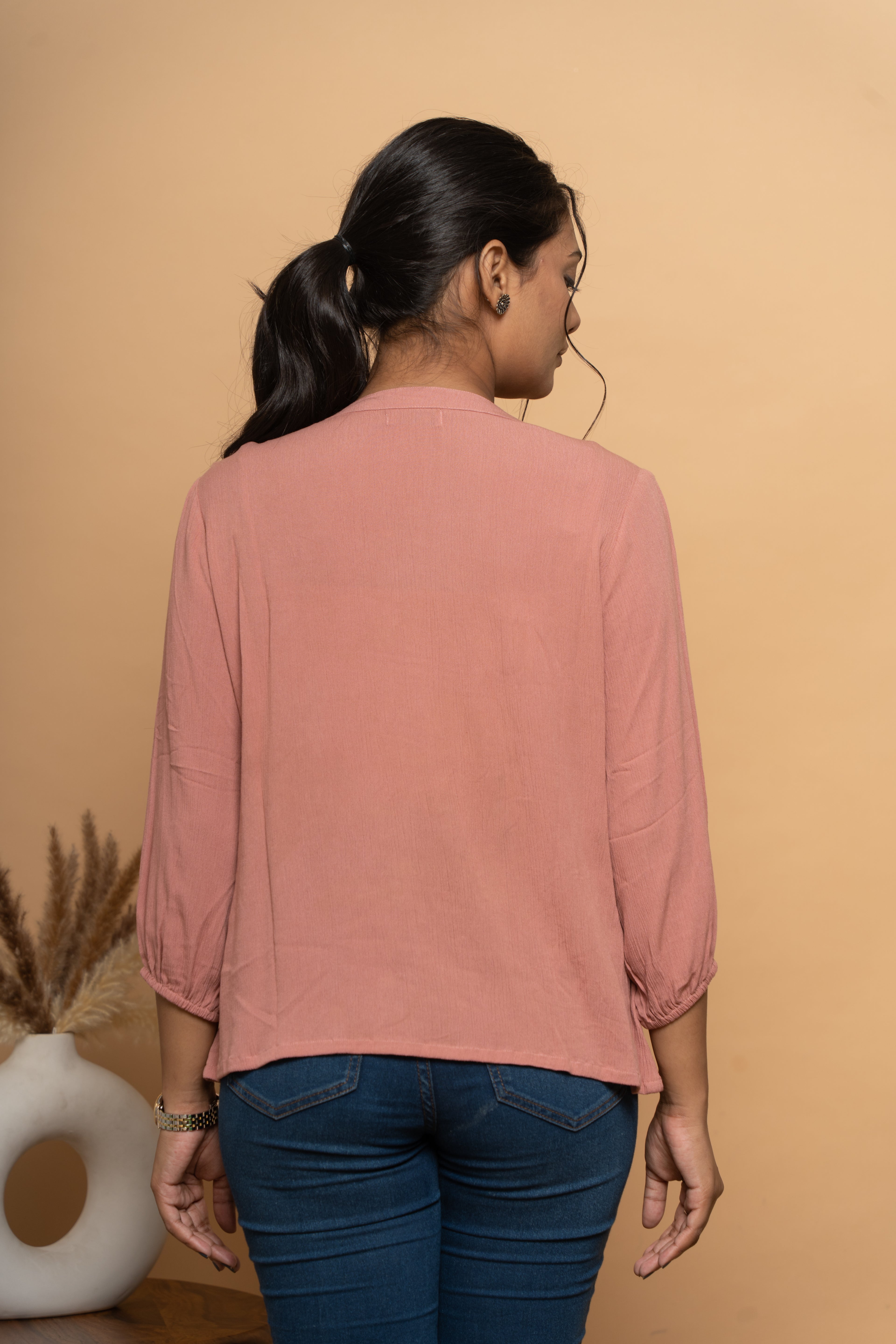 Back view of women’s pink embroidered top by Poshida