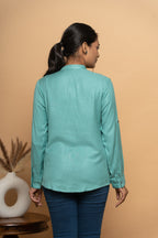 Back view of women’s light blue embroidered shirt by Poshida