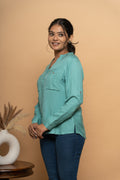 Side view of light blue embroidered women’s shirt by Poshida