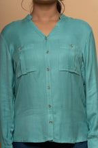 Close-up embroidery detail on light blue shirt by Poshida